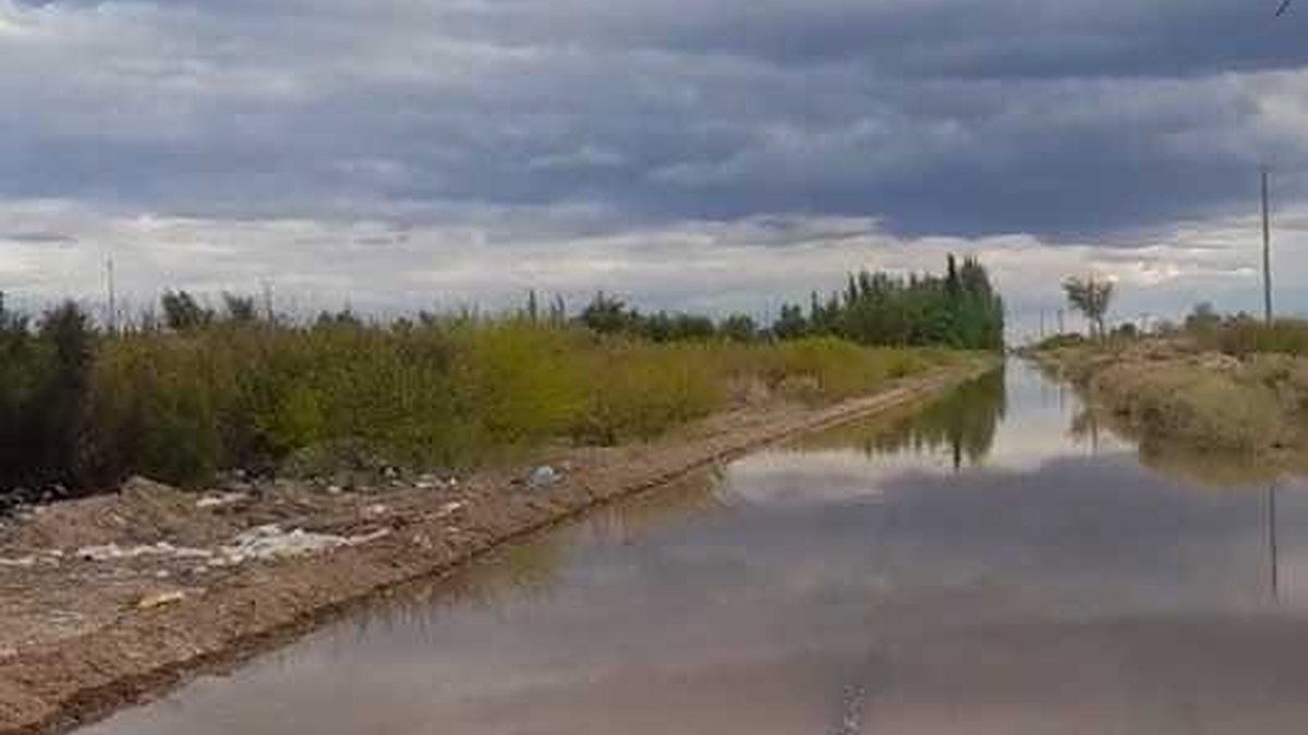 Calle de tierra cubierta de agua en Colonia Fiscal, Sarmiento