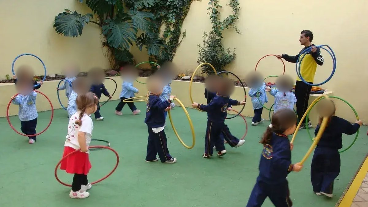 Clase de educación física con aros en un patio