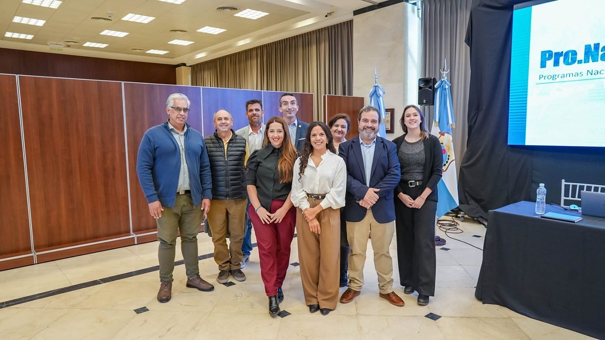 Integrantes del Consejo de Profesionales de Higiene y Seguridad posan en un salón con banderas argentinas