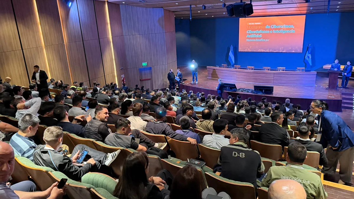 Auditorio lleno de asistentes frente a un escenario con una pantalla que anuncia el Primer Congreso de Cibercrimen, Ciberdefensa e Inteligencia Artificial
