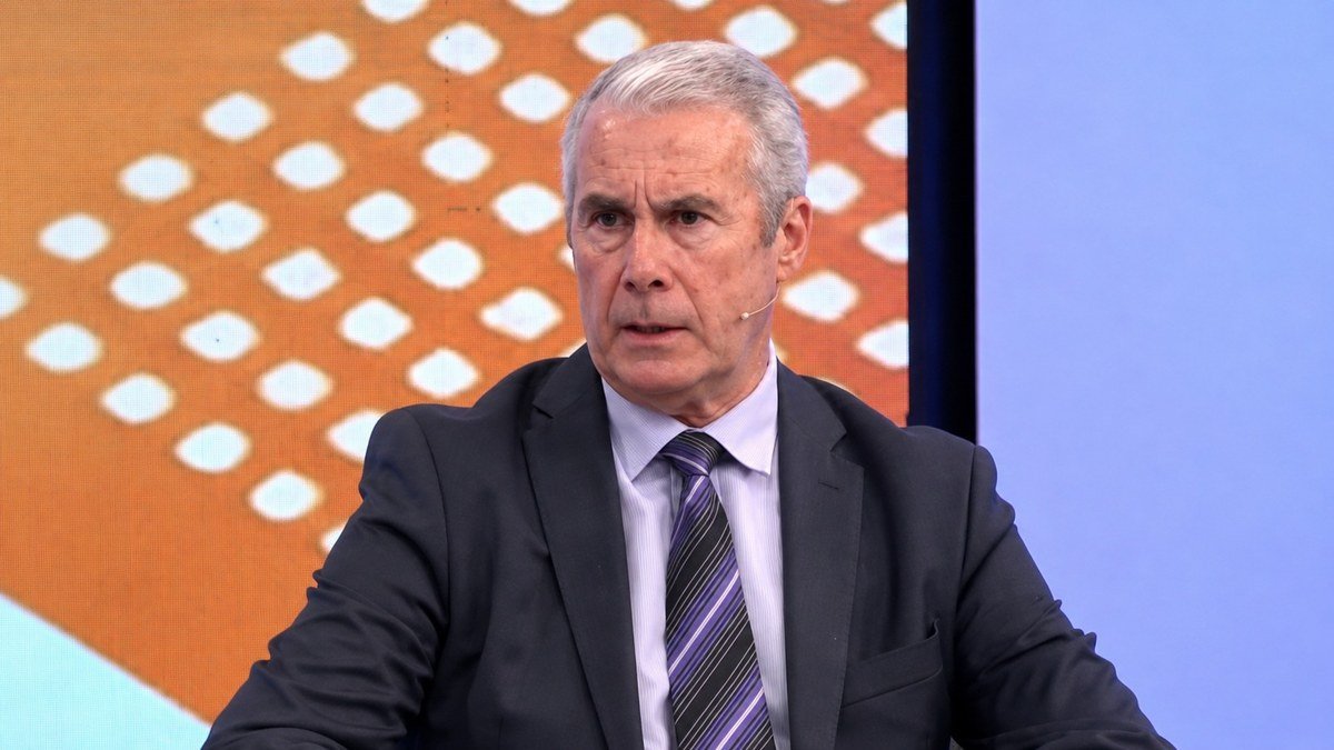 Roberto Ferrero, de traje oscuro y corbata a rayas, habla en un estudio de televisión