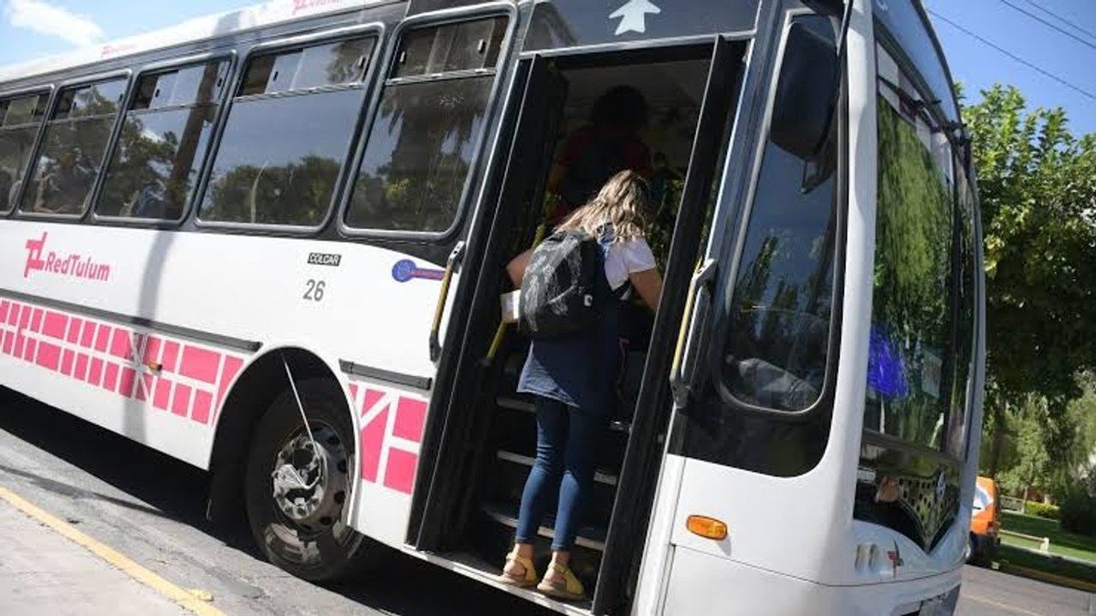 Pasajera subiendo a un colectivo blanco de la Red Tulum en San Juan