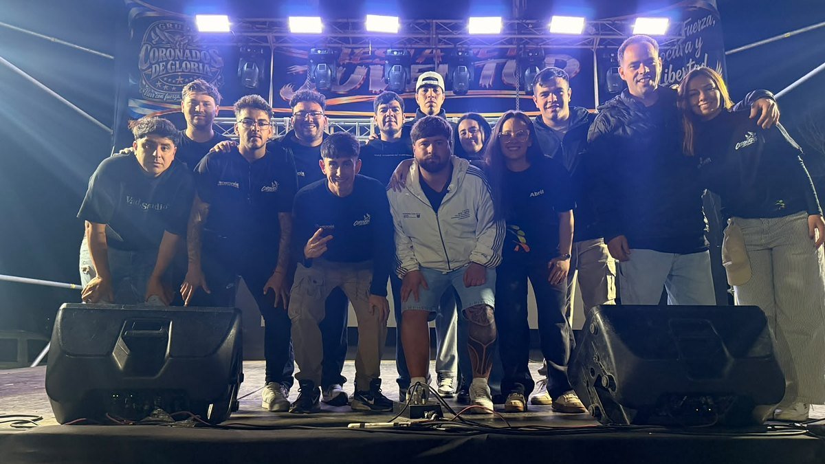 Integrantes de Coronados de Gloria y de la organización posan abrazados sobre el escenario de la Fiesta de la Juventud en Los Berros