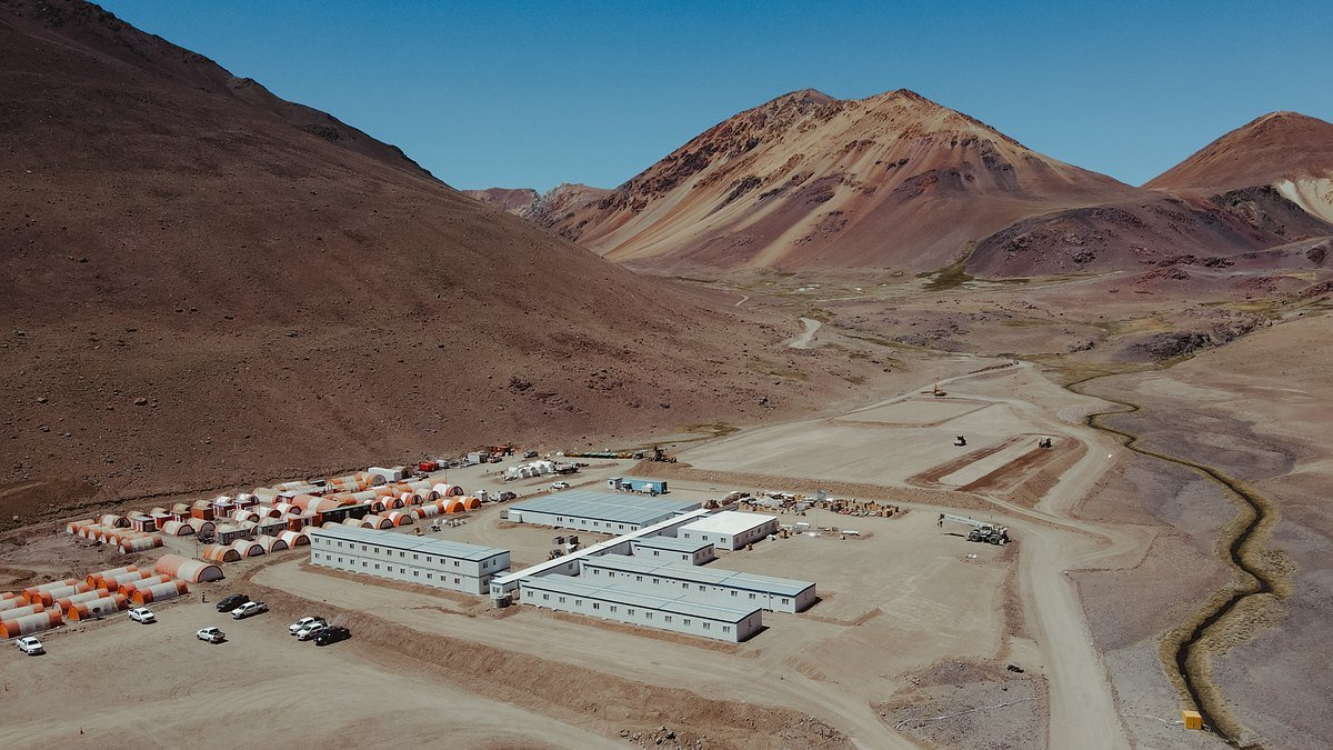 Vista aérea de un campamento minero con módulos entre montañas áridas