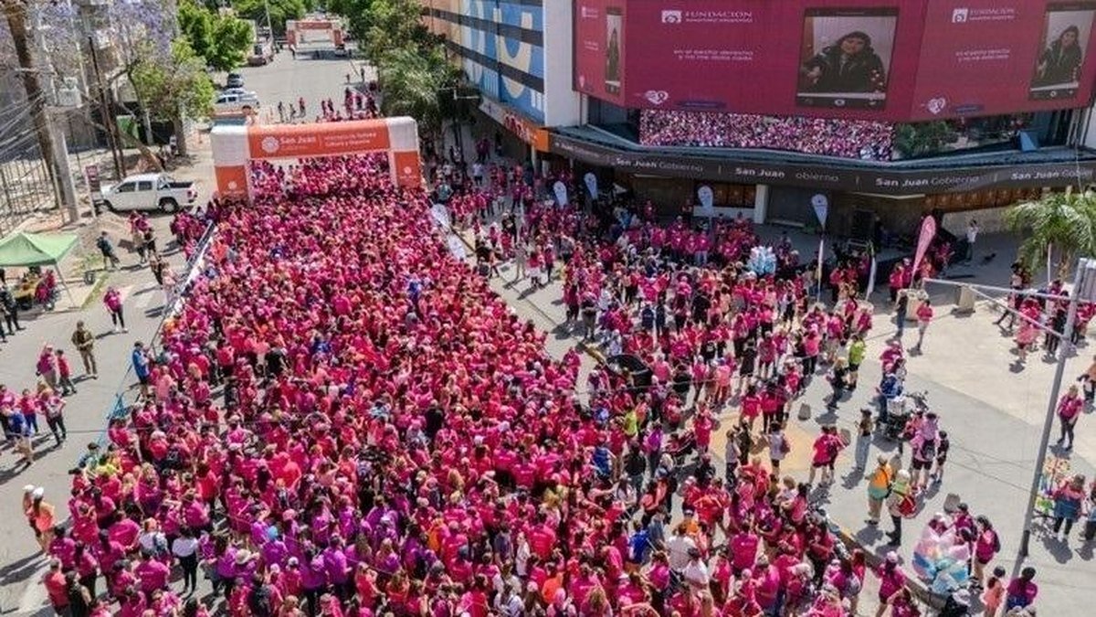 Multitud vestida de rosa en una calle de San Juan durante una maratón contra el cáncer de mama