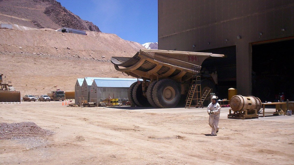 Instalaciones y talleres de la mina Veladero, con un camión minero y montañas áridas