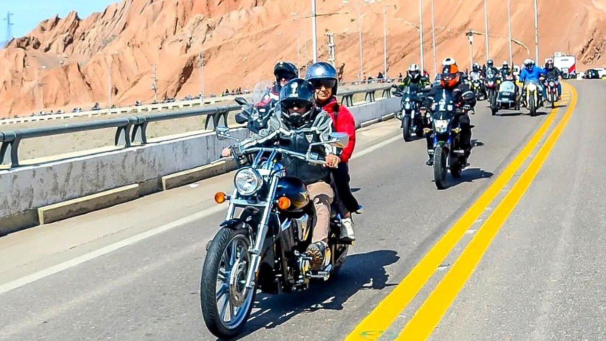 Caravana de motociclistas con casco por una ruta de montaña en San Juan