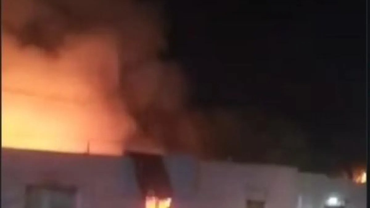 Llamas y humo salen de una vivienda de una planta durante la noche