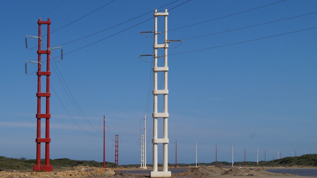 Postes y cables de un tendido eléctrico bajo el cielo azul