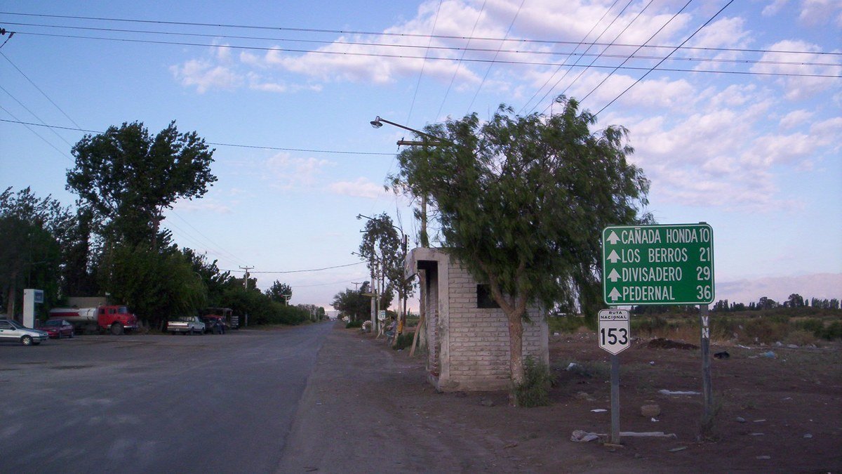 Ruta 153 con un cartel verde que indica Cañada Honda, Los Berros, Divisadero y Pedernal
