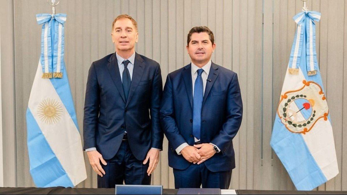 Diego Santilli y Marcelo Orrego posan de traje entre las banderas de Argentina y de San Juan