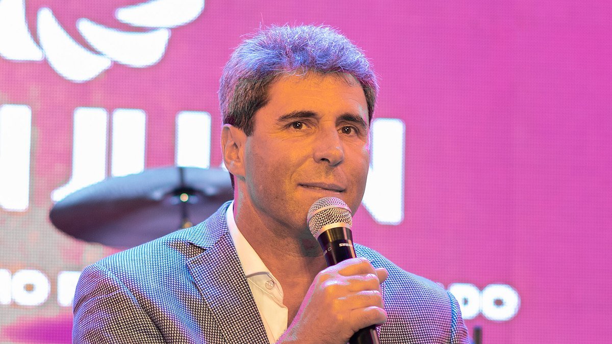 Sergio Uñac habla con un micrófono en la mano durante un acto