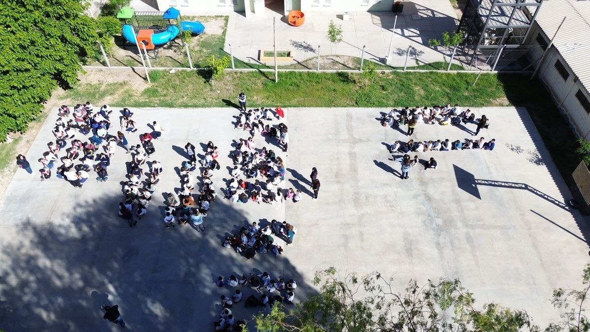 Vista aérea de estudiantes agrupados en el patio de una escuela de San Juan durante un ensayo de evacuación por sismo