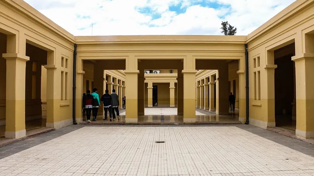 Estudiantes caminan de espaldas por el patio de una escuela de San Juan