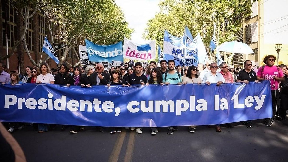 Autoridades de la UNSJ encabezan la Marcha Federal Universitaria en San Juan detrás de una bandera
