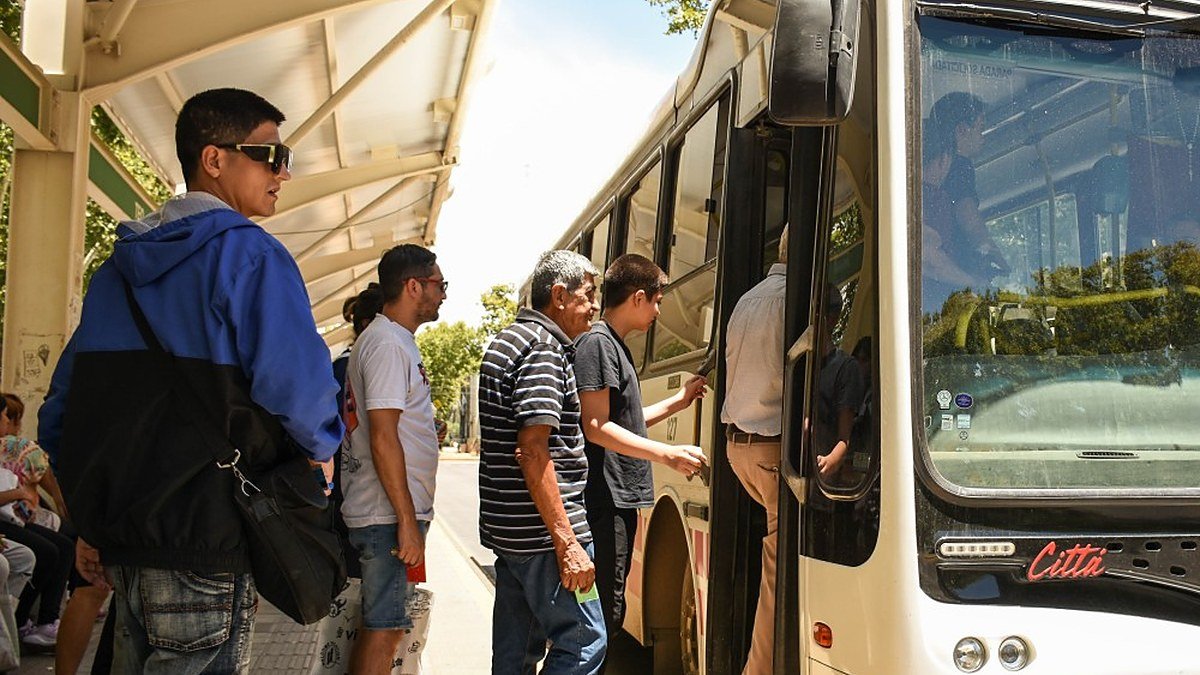 Pasajeros suben a un colectivo en una parada de San Juan