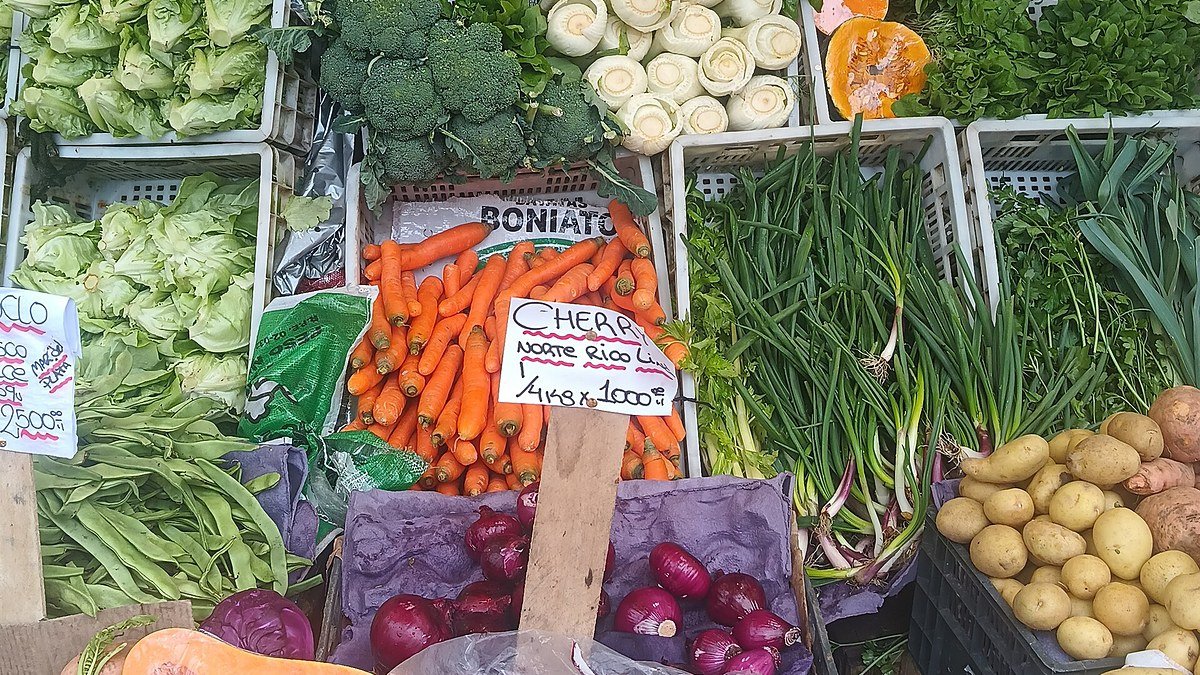 Puesto de verduras y hortalizas en cajones en una verdulería