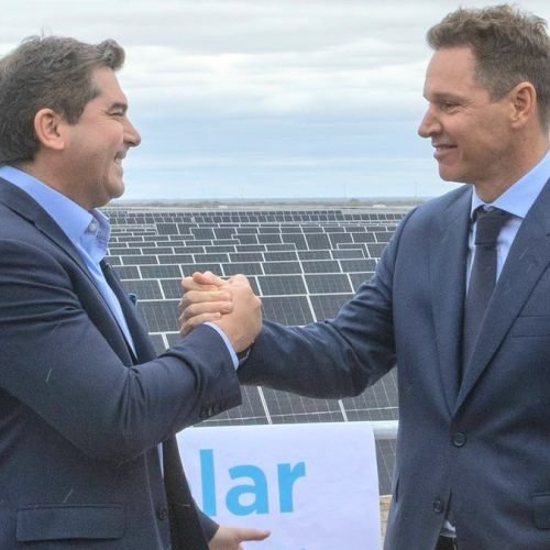 El gobernador Marcelo Orrego y Jorge Brito se dan la mano frente a los paneles del parque solar