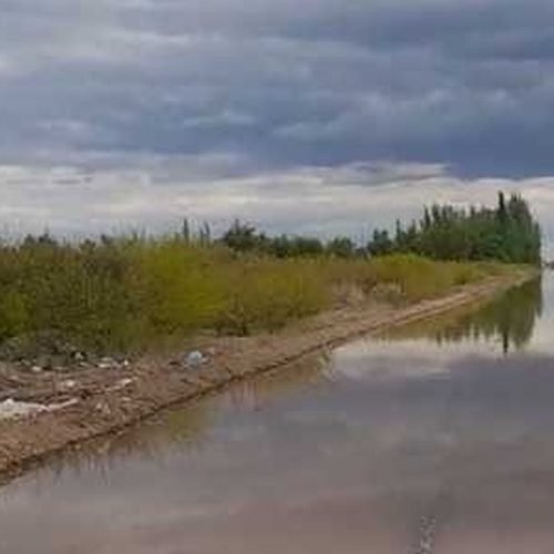 Calle de tierra cubierta de agua en Colonia Fiscal, Sarmiento