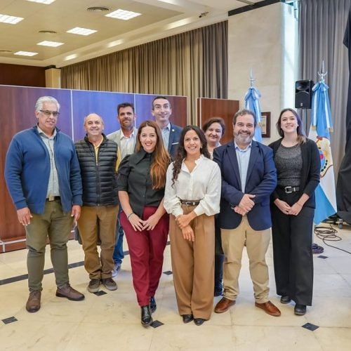 Integrantes del Consejo de Profesionales de Higiene y Seguridad posan en un salón con banderas argentinas