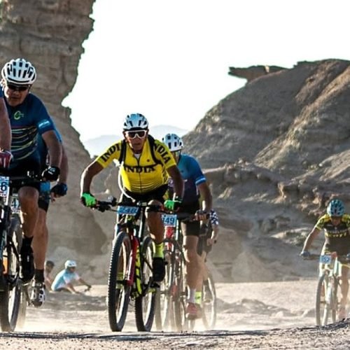 Ciclistas de mountain bike pedalean por un camino de ripio entre formaciones rocosas de Ischigualasto