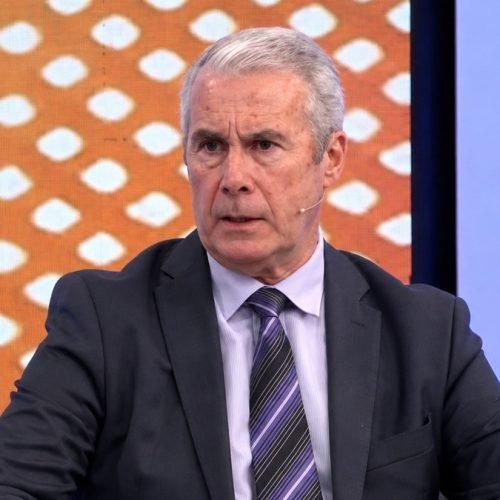 Roberto Ferrero, de traje oscuro y corbata a rayas, habla en un estudio de televisión