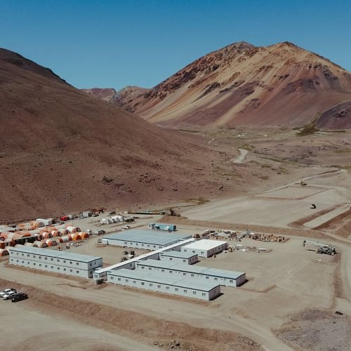 Vista aérea de un campamento minero con módulos entre montañas áridas