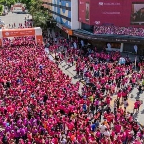 Multitud vestida de rosa en una calle de San Juan durante una maratón contra el cáncer de mama