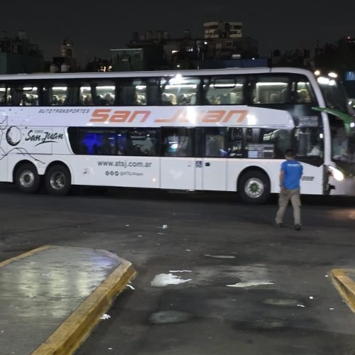 Colectivo de larga distancia de Autotransportes San Juan estacionado en una terminal de noche