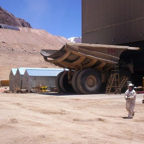 Instalaciones y talleres de la mina Veladero, con un camión minero y montañas áridas