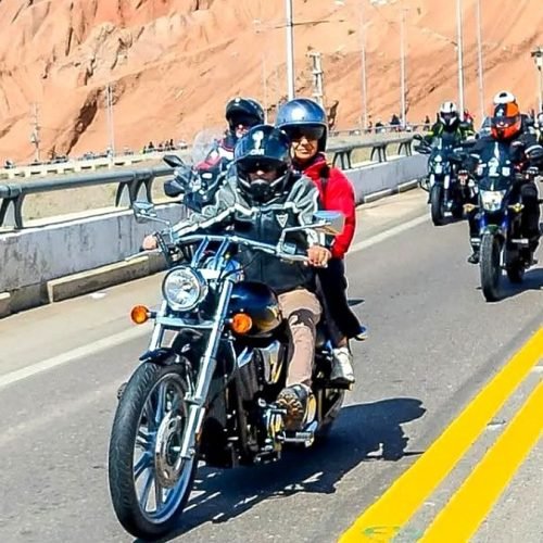 Caravana de motociclistas con casco por una ruta de montaña en San Juan