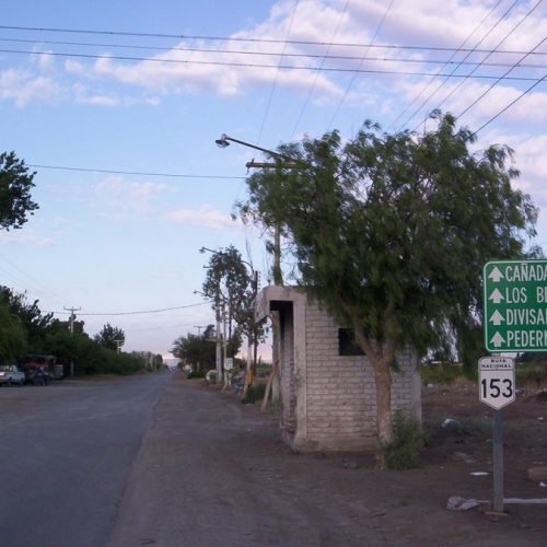 Ruta 153 con un cartel verde que indica Cañada Honda, Los Berros, Divisadero y Pedernal