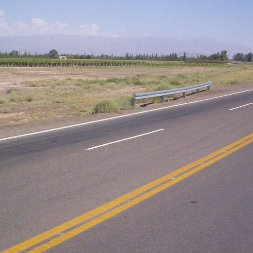 Ruta de dos carriles con doble línea amarilla atravesando una zona rural de San Juan
