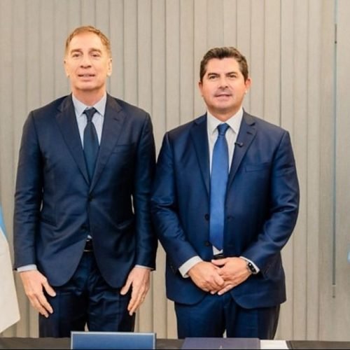 Diego Santilli y Marcelo Orrego posan de traje entre las banderas de Argentina y de San Juan