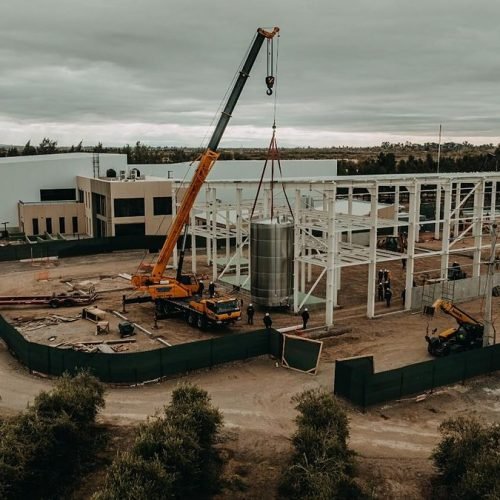 Vista aérea de una planta industrial en construcción con una grúa