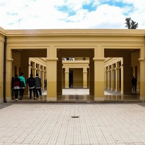 Estudiantes caminan de espaldas por el patio de una escuela de San Juan